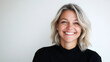 © Helga - A happy, pretty woman with fair hair smiling at the camera with satisfaction, dressed in casual clothes, captured in a studio setting against a plain white wall. smiling woman, fai