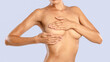 © Prostock-studio - Breast Cancer Awareness Month In October, Self Screening. Young woman examining her bust standing isolated on blue studio background, closeup. Healthcare, Breast Self-Exam BSE Test Concept