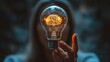 © gustav - A person holds a glowing light bulb with a brain illustration, representing creativity and innovation, set against a blurred background for a modern visual impact