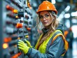 © webdesign - An engineer in safety gear operating a control panel in an industrial factory setting.