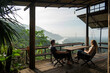© Allison - Couple enjoying morning coffee on a terrace overlooking lush hills and a river