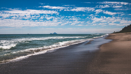 Wall Mural - Beautiful ocean views sandy soft beach new zealand blue sky idyllic picture perfect iconic calm summer day