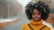 © imagineRbc - A young woman stands on a quiet, fog-covered road surrounded by autumn foliage. She wears a vibrant yellow sweater and displays her beautiful natural hair, radiating confidence