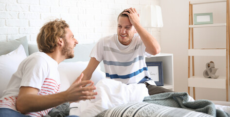 Wall Mural - Young gay couple in quarrel at home. LGBT concept