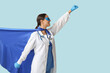 © Pixel-Shot - Beautiful female doctor dressed as super hero on blue background
