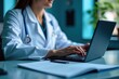 © SimpleDesignStudio - Healthcare Professional in Lab Coat Working on Laptop in Modern Medical Office Environment: Focus on Digital Health Solutions and Telemedicine