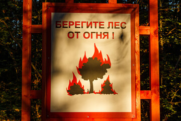 Warning sign in a forest park with the inscription in Russian Protect the forest from fire, Russia