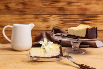 Glass plate with piece of sweet vanilla cheesecake on wooden background