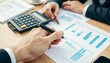© Amish - close-up view of a client reviewing an insurance plan document with a pen and calculator