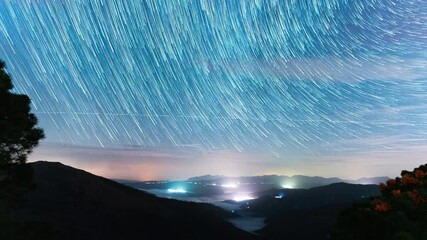 Wall Mural - stars trail over spain landscape with mountains and cities, time lapse view