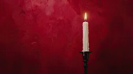 Wall Mural - Elegant candle glowing against a rich red backdrop