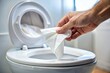 © Wanlop - Close-up Hand Discarding Tissue in Toilet Bowl - Avoid Clogged Toilet