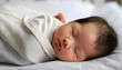 © tenpadasi - ベビーベッドに横たわり毛布をかけて眠る新生児の赤ちゃん　育児・成長・子育てのイメージ