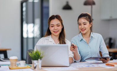 Wall Mural - Asian Business women using calculator and laptop for doing math finance on an office desk, tax, report, accounting, statistics, and analytical research concept
