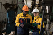 © amorn - Diversity factory worker working in factory. Male and female engineer wearing safety uniform, helmet and gloves at work factory. Group of worker working at factory