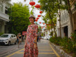 © YURII Seleznov - Young woman in ethnic dress and hat exploring the festive streets of George Town, Malaysia, during Chinese New Year. Vibrant lanterns, cultural celebrations, and historic charm create a unique atmosph