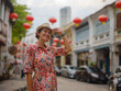 © YURII Seleznov - Young woman in ethnic dress and hat exploring the festive streets of George Town, Malaysia, during Chinese New Year. Vibrant lanterns, cultural celebrations, and historic charm create a unique atmosph