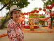 © YURII Seleznov - Young woman in ethnic dress and hat exploring the festive streets of George Town, Malaysia, during Chinese New Year. Vibrant lanterns, cultural celebrations, and historic charm create a unique atmosph