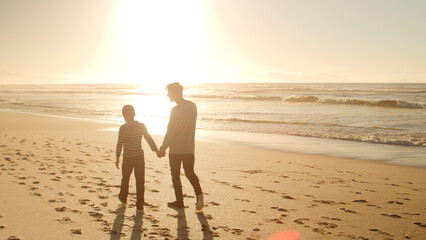 Wall Mural - Father And Son On Holiday Walking Along Winter Beach Hand In Hand