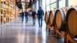 © siraphol - Whiskey distillery tour with visitors walking past wooden barrels