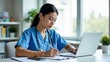 © Abi - Focused Medical Professional Working on Patient Records at Her Office Desk