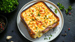 © Akash Tholiya - Top down view of a white plate with croque monsieur, French grilled ham and cheese sandwich with béchamel sauce, on a black textured background