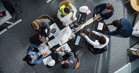Aufkleber - Top Down View of Diverse Team of Real Estate Construction Engineers Discussing Blueprints, Documents in Corporate Office. Modern Workspace of Architectural Bureau With Colleagues Using Tablet, Laptop.