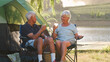 © Monkey Business - Senior Couple On Camping Trip In Countryside By Lake Relaxing With Drinks
