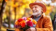© Mrammon - A happy elderly man sitting in a wheelchair, holding flowers brought by his family.