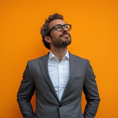 Happy business man executive standing looking and dreaming of future business success, thinking of new goals, business vision and leadership concept on orange background