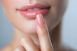 © Marut - close up of woman lips and manicured nails, showcasing soft pink nail polish and subtle smile. image conveys sense of beauty and elegance
