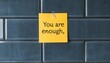 © JP STUDIO LAB - A simple but impactful photo of a sticky note on a mirror that says, 'You are enough,' encouraging self-love