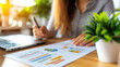 © Pixel Alchemist - woman analyzing financial report with charts and graphs in bright office
