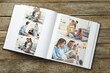 © New Africa - Different photos in open photo album on wooden table, top view