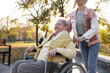 © New Africa - Caregiver with elderly woman in wheelchair at park