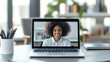 © Sunday Cat Studio - A woman smiling during a video call on her laptop in a modern workspace.