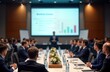 © Vadym - Business people attend roundtable discussion at convention center. Speaker gives presentation to large audience. Attendees focused on information shared. Pro setting with large conference room.