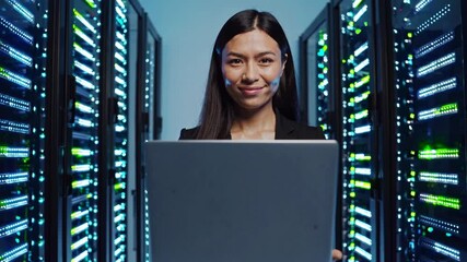 Leinwandbilder - Smiling woman holds laptop among glowing servers in modern data center