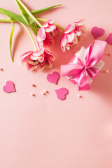 Wall Mural - Pink tulips and hearts, gift box with ribbon on light pink background