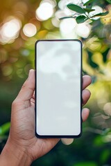 Poster - Individual holds a smartphone with a blank screen against a blurred backdrop of lush green foliage