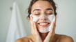 © igor.nazlo - Smiling young woman washing foam face by natural foamy gel. Satisfied girl with bare shoulders applying cleansing beauty product on cheeks closed eyes. Personal hygiene, skincare daily routine