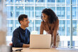 © insta_photos - Busy happy business people work team colleagues using laptop computer working together in office. Two diverse employees professionals discussing financial data at corporate business meeting.