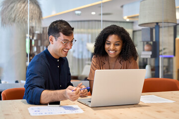 Aufkleber - Smiling team professional employees working together on computer discussing online technology data solutions at work. Two young busy diverse coworkers business people using laptop at office meeting.