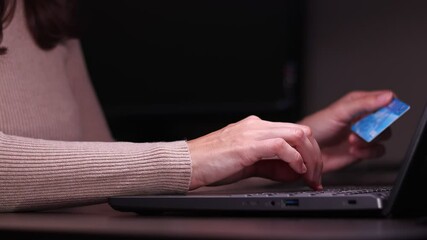 Female hands of cardholder holding credit card making e bank online payment. Woman consumer paying for purchase in web store using laptop technology. Ecommerce website payments concept. Close up view.