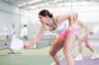 © JackF - Expressive resolved sporty young girl playing pickleball in indoor court, ready to hit ball with paddle. Sport and active lifestyle concept..