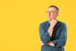© Pixel-Shot - Thoughtful mature man in eyeglasses on yellow background