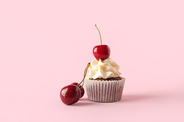 Wall Mural - tasty cherry cupcake on pink background