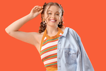 Wall Mural - Happy smiling young woman with braids on orange background