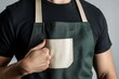 © BerkahStock - Man wearing a green apron with a beige pocket.