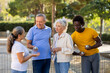 © JackF - Excited multinational people listening to explanations about petanque game against trees in afternoon park